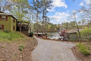 A house with a gravel path leading to a dock by a lake, surrounded by trees and vegetation. - Come Relax @ The Hideaway Lakehouse - Walnut Creek, Lake Mitchell, Clanton - AL (Clanton)