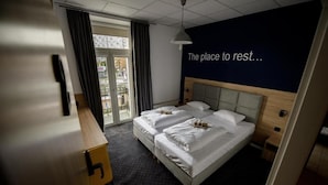 A hotel room with a bed, a desk, and a view of the outdoors. - ONRest Hostel (Kielce)