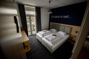Habitación de hotel con cama, escritorio y vistas al exterior.
