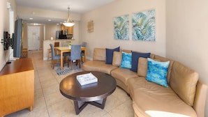 A modern living room with a sofa, coffee table, and dining area. - Crystal Palms 207 (Treasure Island)