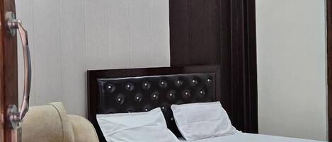 Un dormitorio con una cama, una silla y una mesita de centro.