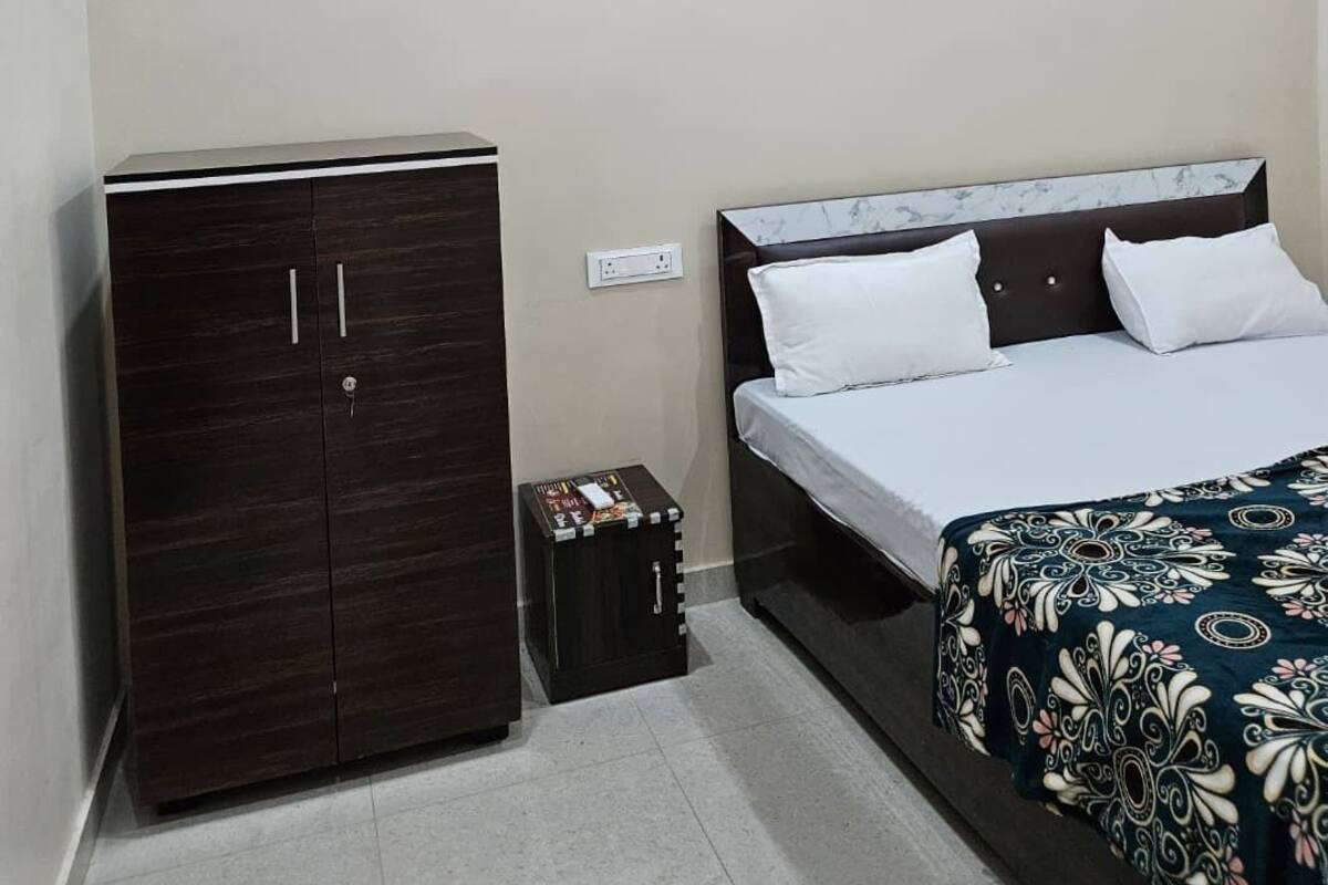 A bedroom with a bed, a wardrobe, and a small table.