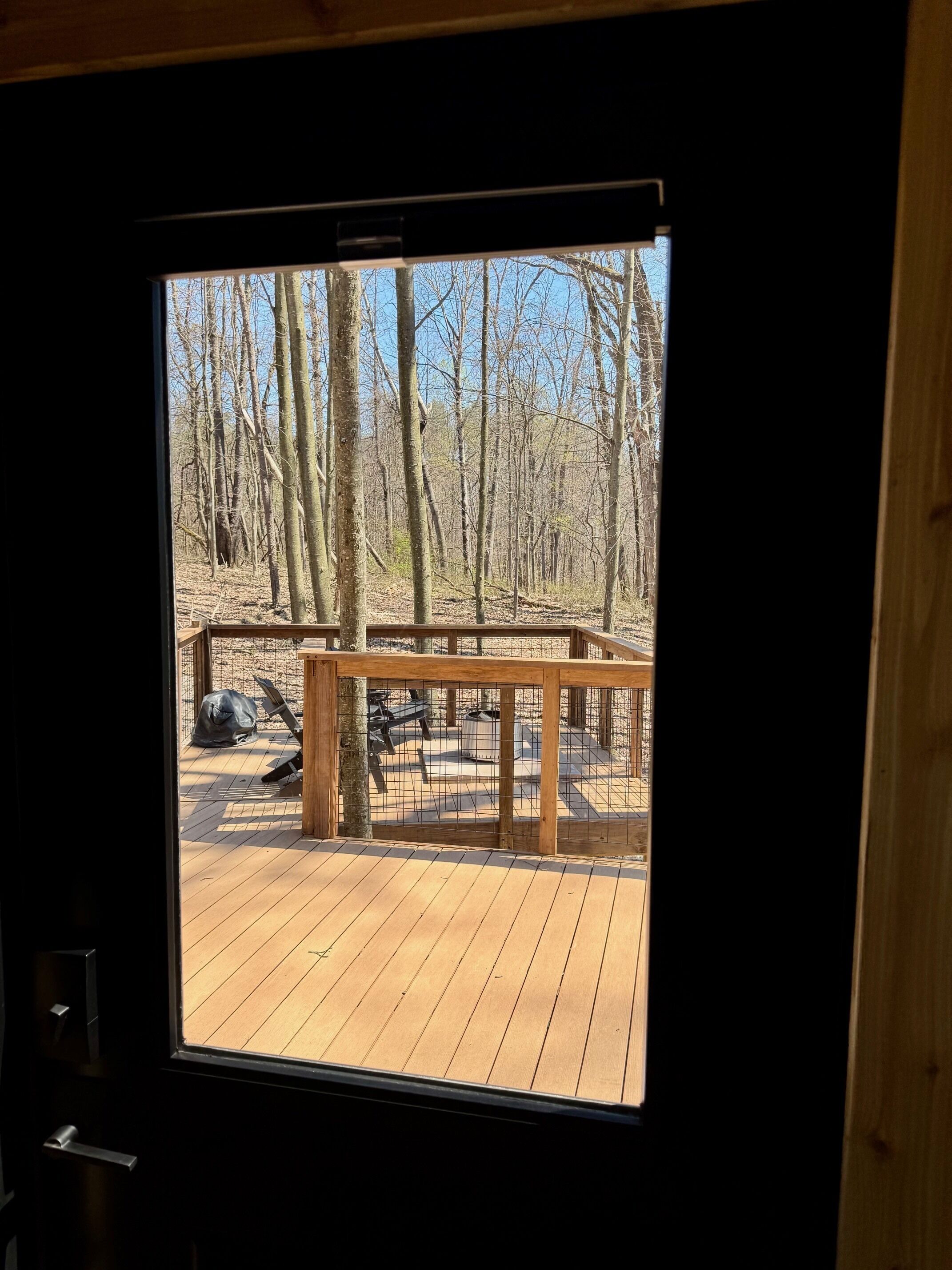 Une terrasse en bois avec une rambarde en métal, un banc et une table de pique-nique.