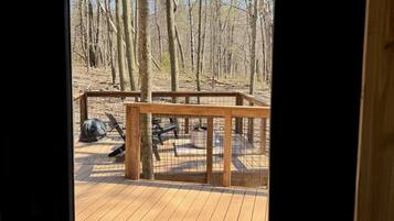 Une terrasse en bois avec une rambarde en métal, un banc et une table de pique-nique.