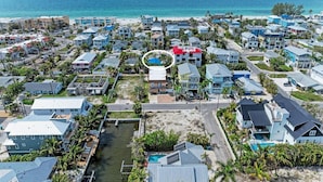Ett bostadsområde vid kusten med hus, en strand och en liten vattenväg.