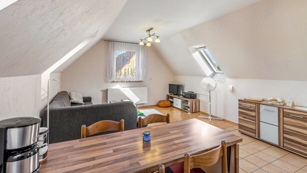 Een moderne loft met een eethoek, kitchenette en een groot raam.
