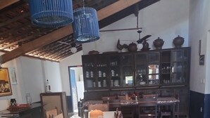 A long dining table with chairs, a vase, and a blue hanging light fixture. - Hotel fazenda serrota t (Currais Novos)