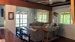 Un salon confortable avec un canapé, une table en bois et un ventilateur de plafond.