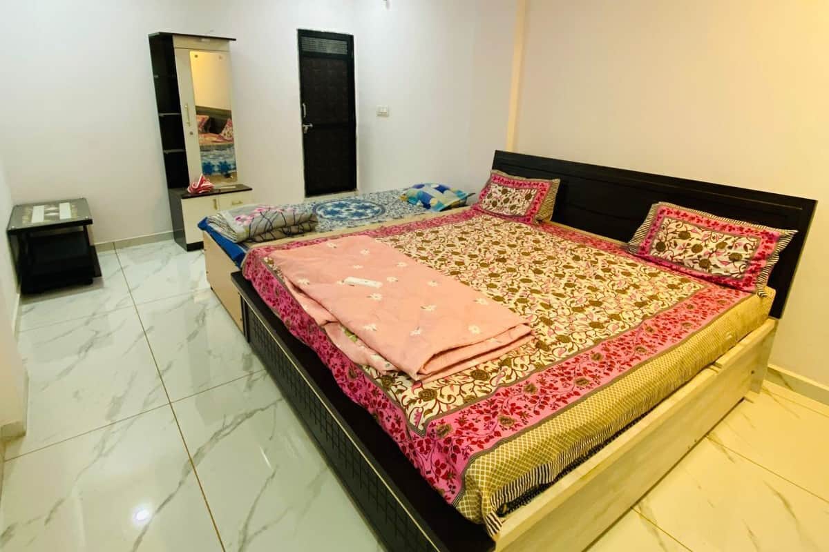 A bedroom with a bed, a wardrobe, a mirror, and a ceiling fan.