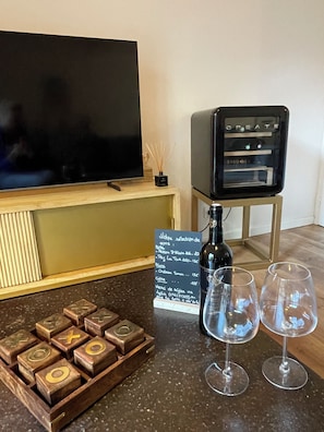 Eine Bar mit Fernseher, einer Weinflasche, zwei Gläsern und einer Speisekarte.