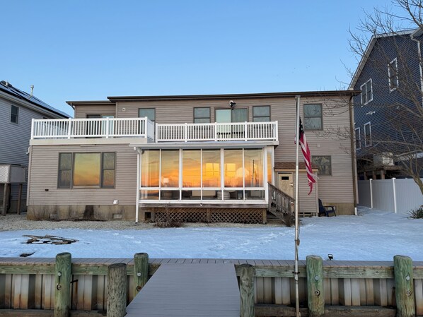 A two-story house with a balcony, a deck, and a flag.