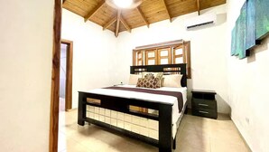 Un dormitorio con techo de madera, una cama con cabecera, una mesita de noche y un equipo de aire acondicionado.