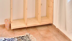 Un armario de madera con varios compartimentos y perchas.