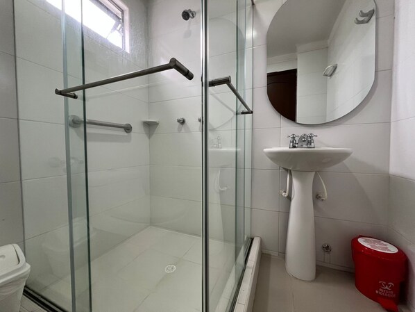 A modern bathroom with a glass-enclosed shower, a white sink, and a mirror. - Hotel Suite Santa Rosa (Santa Rosa de Cabal)