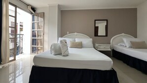 A hotel room with two beds, a large window, a balcony, and a mirror on the wall.
