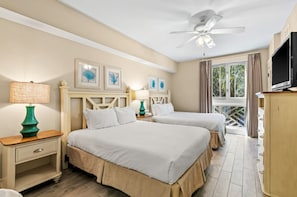 A hotel room with two beds, a ceiling fan, a TV, and a window with curtains. - Market Street Inn 234 (Miramar Beach)