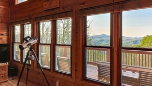 A wooden cabin with large windows, a telescope, and a sign indicating 'Crooked Creek Mountain Lodge.' - Blue Ridge Overlook Lodge | Blue Ridge, GA (Cherry Log)
