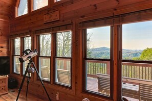 Eine Holzhütte mit großen Fenstern, einem Teleskop und einem Schild mit der Aufschrift 'Crooked Creek Mountain Lodge'.
