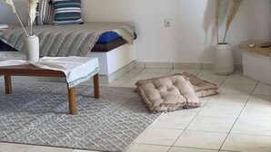 Un soggiorno con divano, tavolino, tappeto e oggetti decorativi.