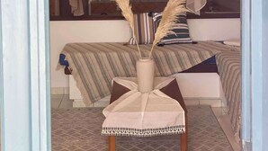 Una camera da letto con un letto, un comodino con un vaso e un baldacchino.