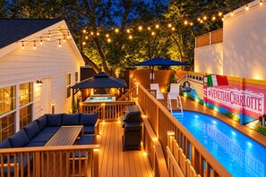 A deck with a hot tub, lounge chairs, and a swimming pool. - 2 Homes • 2 Hot Tubs • 2 Saunas • 1 Bundle (Charlotte)
