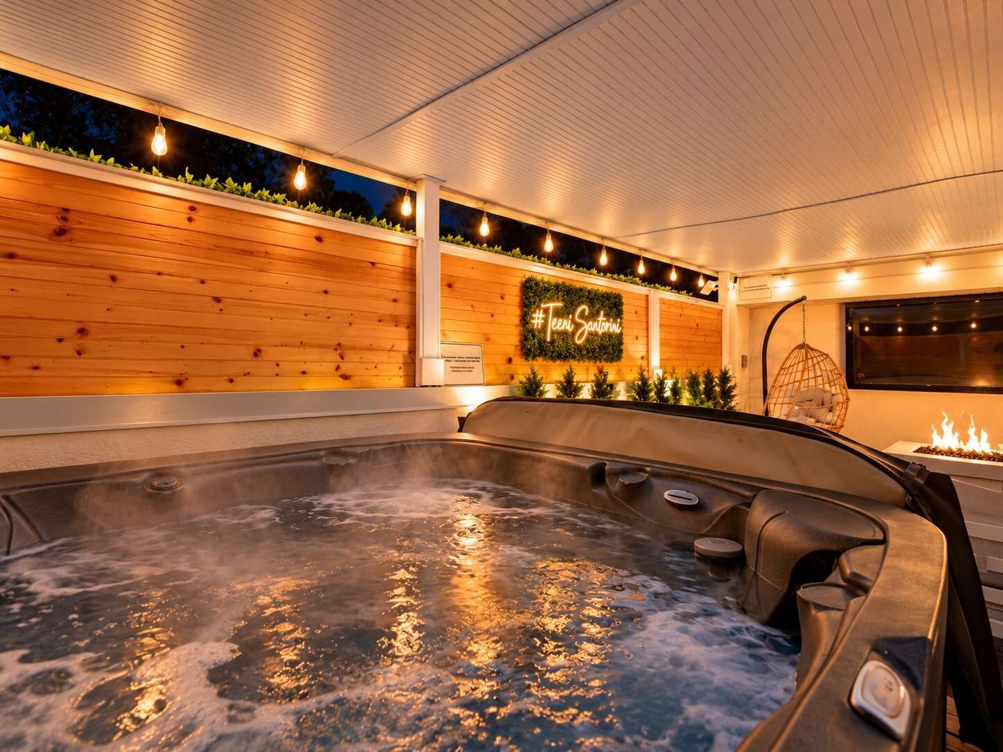 A hot tub area with a wooden wall and a neon sign.