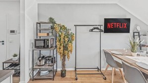 Une cuisine moderne équipée d’un four à micro-ondes, d’une machine à café et agrémentée d’une plante.