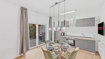 A modern kitchen with grey cabinets, a built-in oven, and a microwave.