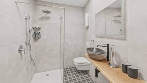 A modern bathroom with a glass shower enclosure, a wooden vanity with a bowl sink, and a toilet.