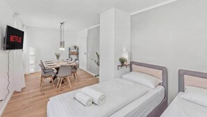 Una habitación de hotel moderna con cama, mesita de noche y escritorio con sillas.