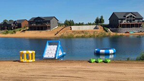 En vacker utsikt över sjön med en sandstrand, en flytande solstol och en roddbåt.