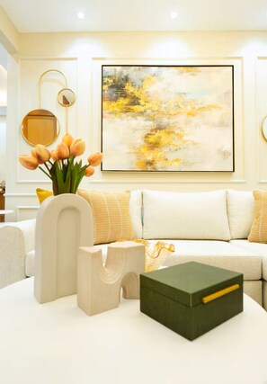 A modern living room with a sofa, decorative vases, and a large abstract painting on the wall. - Comfort and Elegance /Perfect Stay Experience (Santiago de los Caballeros)