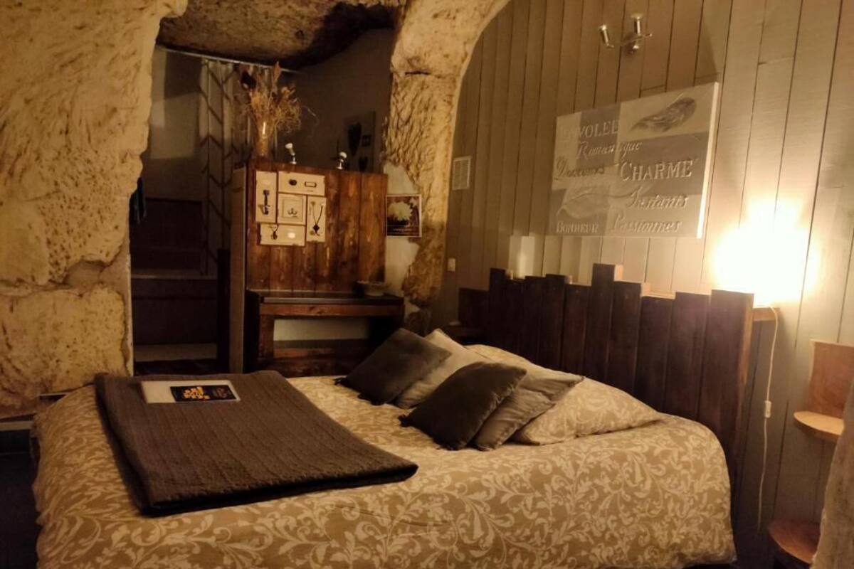 Un dormitorio con una cama, cabecera de madera y un cartel en la pared.
