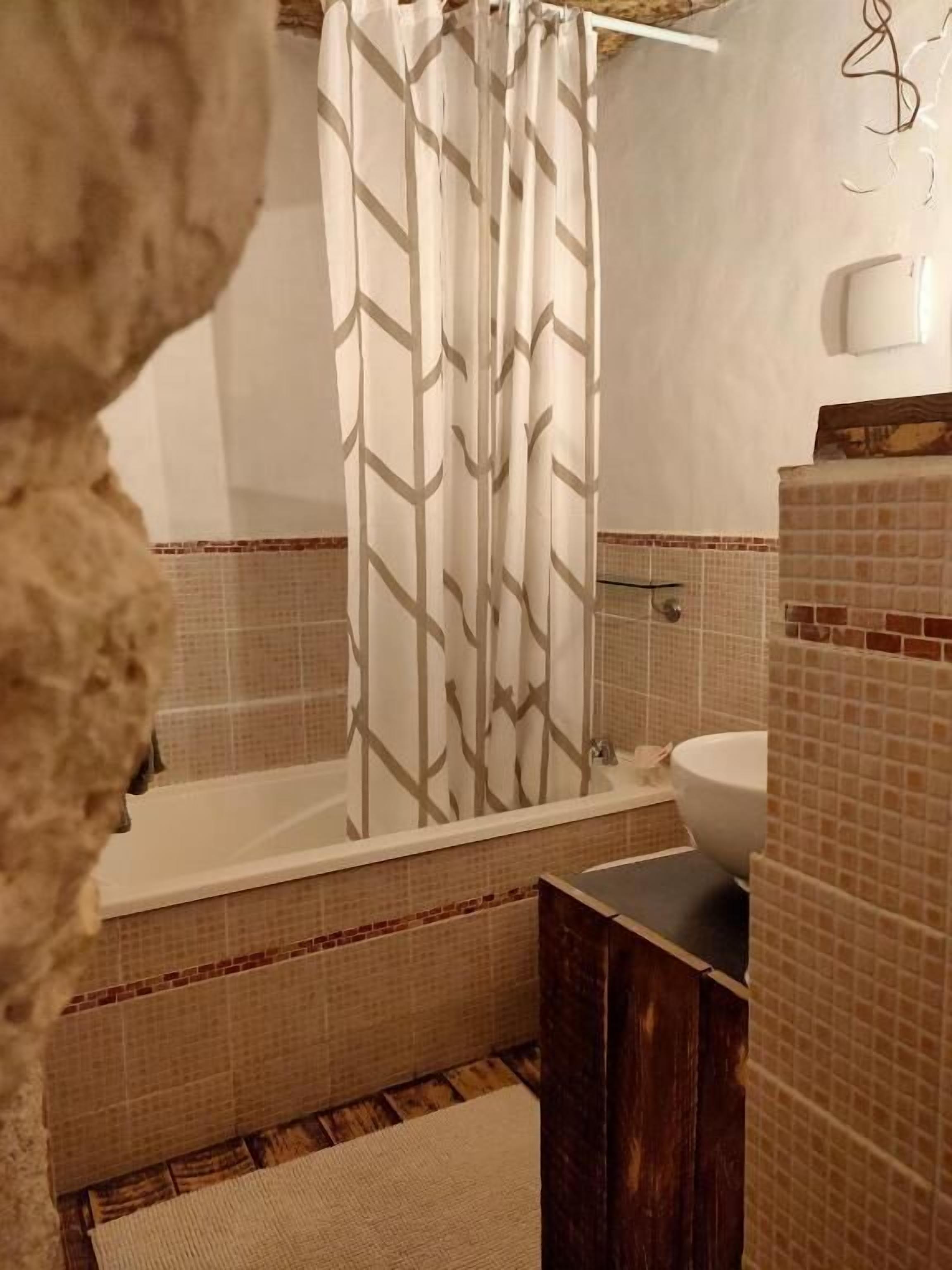 A bathroom with a bathtub, a sink, and a mirror.