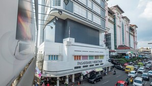 Um edifício com vários andares e uma grande placa com a inscrição 'PASARBARU HERITAGE'.