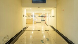 Entrada de hotel com uma placa que diz 'PASARBARD HERITAGE' e piso de azulejos com pegadas.