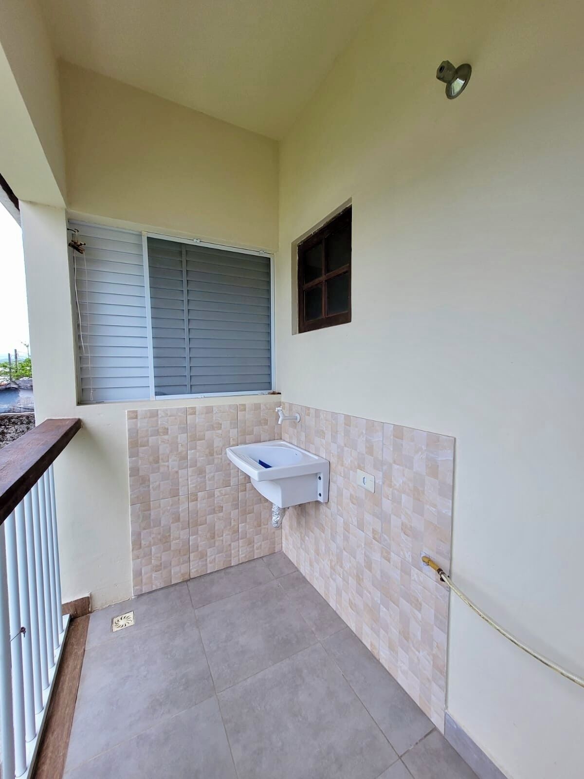 Un baño pequeño con lavabo, ventana y puerta.