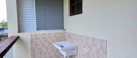 Un baño pequeño con lavabo, ventana y puerta.