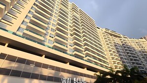 Un immeuble de grande hauteur doté de nombreux balcons et d’une enseigne indiquant « WAI BLUE ».