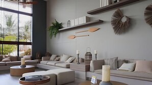 Un salon moderne avec un canapé d’angle, des tables basses rondes et des œuvres d’art décoratives au mur.