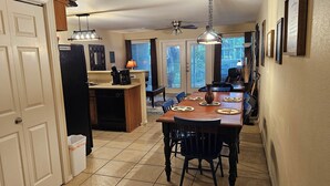 A kitchen with a dining area, a ceiling fan, and a view through the windows. - Bluebonnet Poolside Paradise • Heated Pool • Schlitterbahn 5 Blocks • Sleeps 6 (New Braunfels)