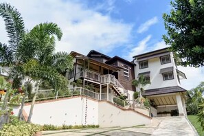 Un immeuble résidentiel à plusieurs étages, doté d’un balcon, d’un escalier et d’un abri-voiture couvert.