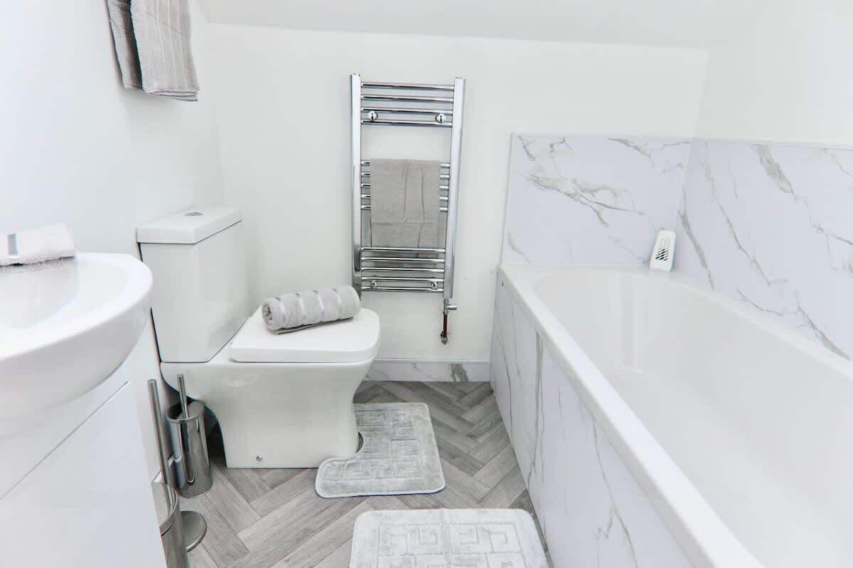 A modern bathroom with a toilet, bidet, and a bathtub.