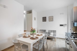 Une cuisine moderne avec un coin repas, des murs blancs et un canapé.