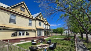 A two-story house with a front porch, a small garden, and a paved driveway. - Welcome to our 1890 Victorian Mansion
Spacious 8-bedroom house in lovely Coleman (Coleman)