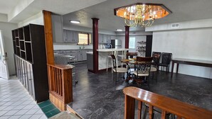 A spacious kitchen with a dining area, a chandelier, and a staircase. - Welcome to our 1890 Victorian Mansion
Spacious 8-bedroom house in lovely Coleman (Coleman)