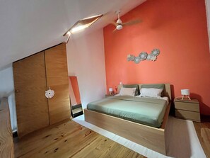 A bedroom with a bed, nightstands, a ceiling fan, and a wall decoration. - Bayahine Downtown Duplex & 5-minute walk to Bayahibe Beach with a pool (Bayahíbe)