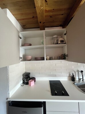 A kitchen with white cabinets, a black countertop, a coffee maker, a toaster, and a dishwasher. - Bayahine Downtown Duplex & 5-minute walk to Bayahibe Beach with a pool (Bayahíbe)