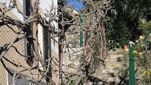 A stone staircase with potted plants and a green post. - Au Petit Bonheur Apart (Rapallo)