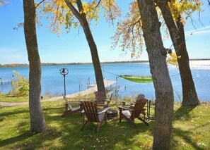 Un cadre idyllique au bord du lac, avec un quai, des chaises et un hamac.